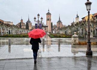 Muchacha con paraguas rojo bajo la lluvia de Semana Santa